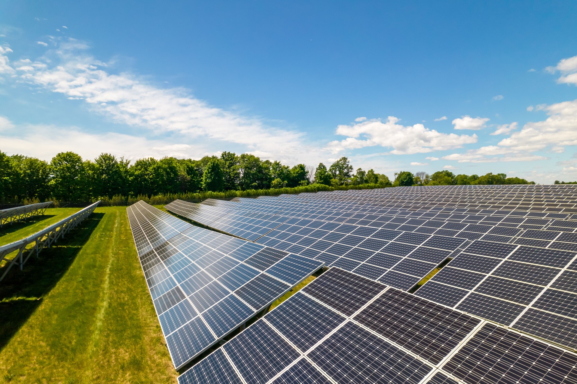 View of modern photovoltaic solar panels to charge battery. Rows of sustainable energy solar panels set up on the farmland. Green energy and environment ecology concept.